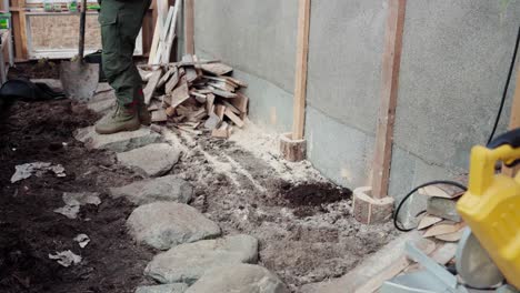 jardinero llenando el suelo del invernadero con tierra usando una pala