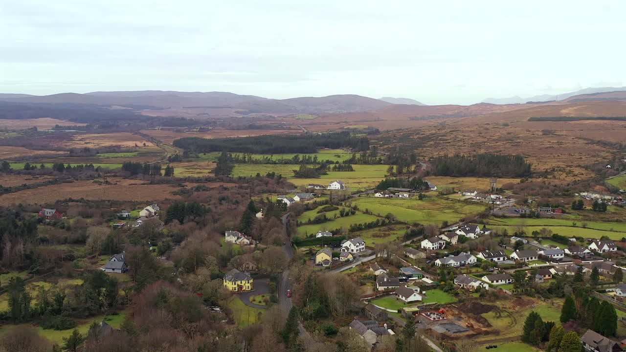 Forward aerial flight over Oughterard, Ireland: Rural homes dotted across Connemara's rugged moorland