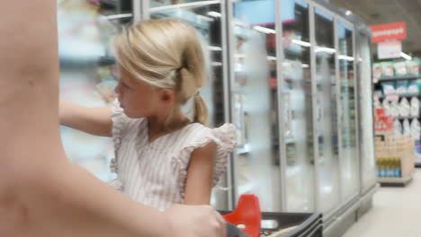 mother pushing shopping cart with child at grocery