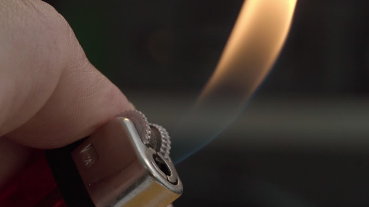 Close-Up of Hand Lighting a Lighter