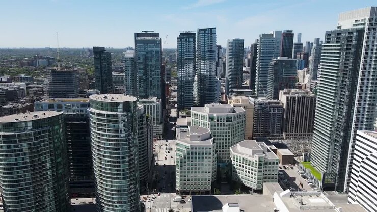 Drone passando entre edifícios no centro de Toronto em um dia de primavera ensolarado.