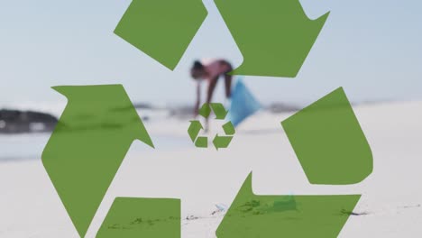 Animation-of-recycling-symbol-over-african-american-woman-collecting-waste-on-beach