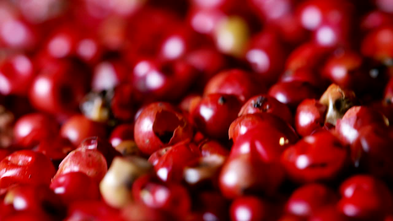 은 고추, 분홍색 고추의 곡물은 극심한 느린 속도로 나무 표면에 떨어지고 서로 여 있습니다.