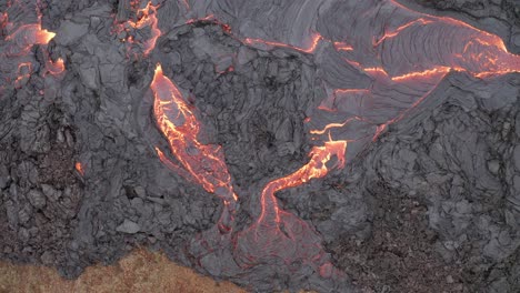 elevándose sobre dos vetas de lava que fluye en el valle de geldingadalur - erupción del volcán fagradallsfjall en el sur de islandia
