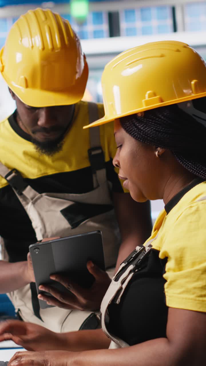 Vertical Video African american workers checking up on manufacturing equipment