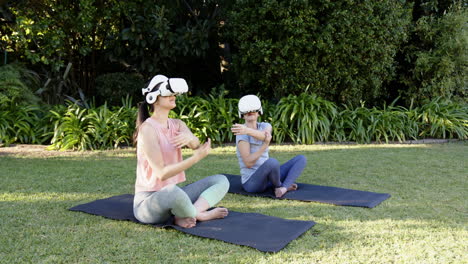 in garden, asian grandmother and granddaughter practicing yoga using vr headsets