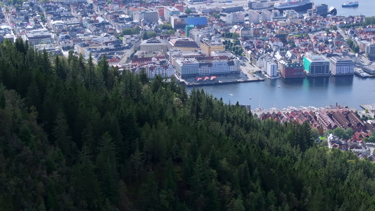 Drone footage flying sideways over Fløyen, gradually exposing Bergen’s buildings and waterfront