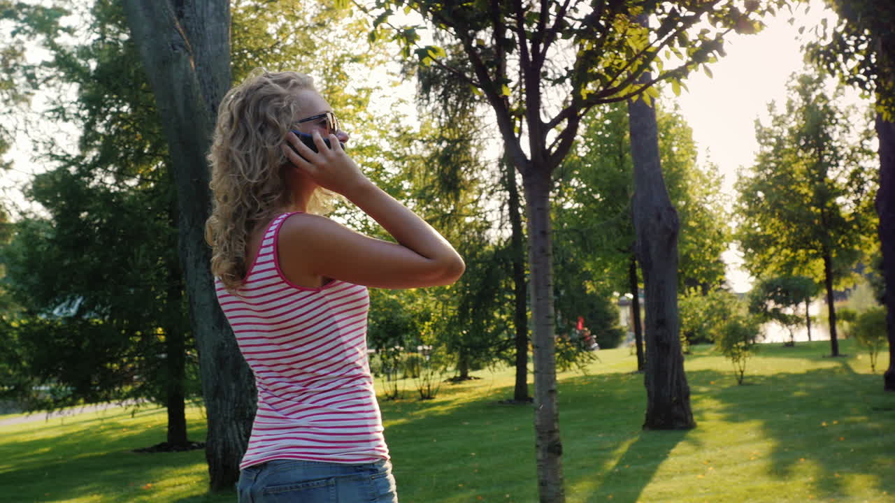 젊은 매력적인 여자가 여름날 잘 손질된 공원에서 산책 5