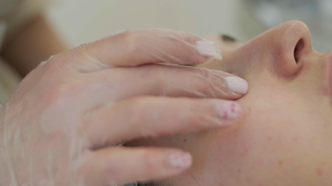 미용 전문가가 얼굴 치료와 얼굴 마스크를 적용합니다.