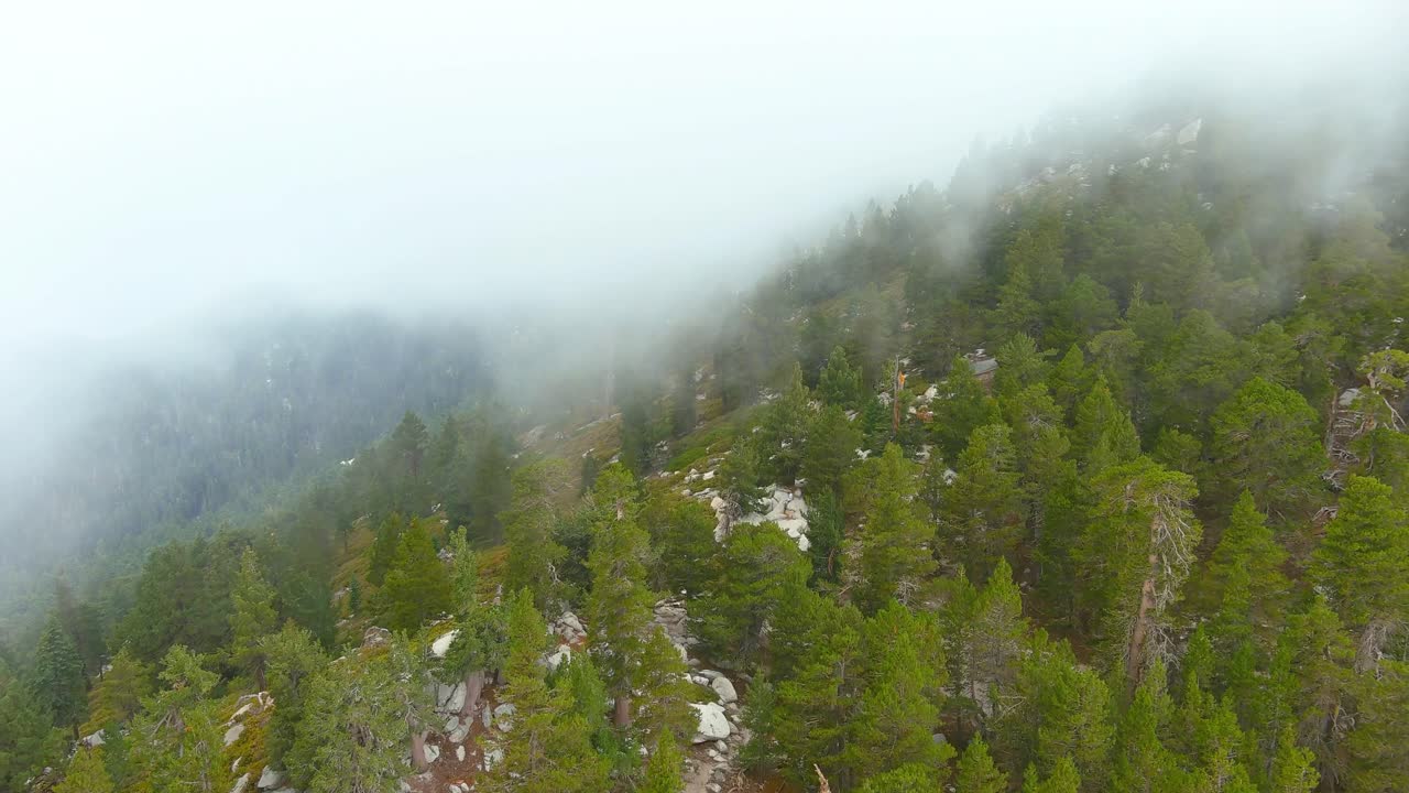 sobrevuelo aéreo sobre el acantilado de la montaña a través de las nubes | tiempo nublado