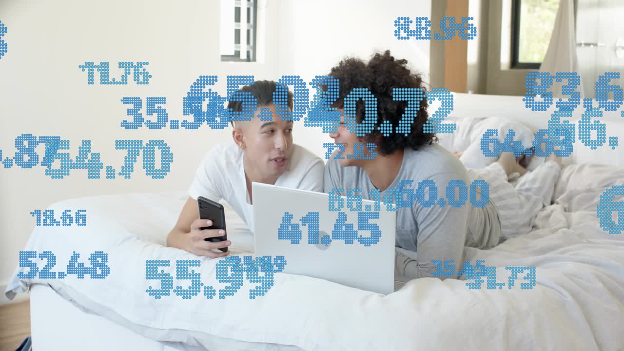 Due uomini a letto condividono il telefono, dati brillanti, digitando su un portatile con numeri blu in sovrapposizione