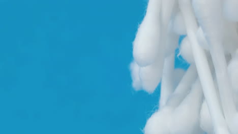 cotton swabs of white color rotate in a circle on a green hygiene products. cotton swabs of white color rotate in a circle on a green . hygiene products