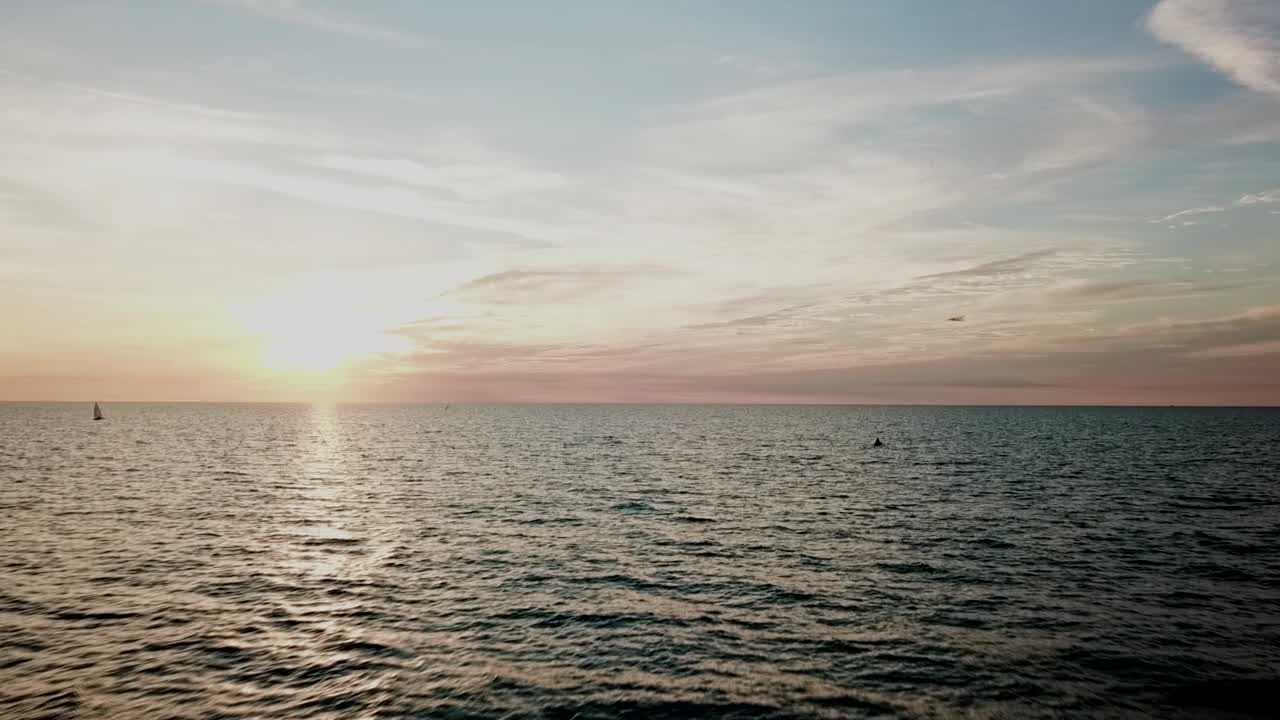 drone vuela cerca del agua hacia el sol