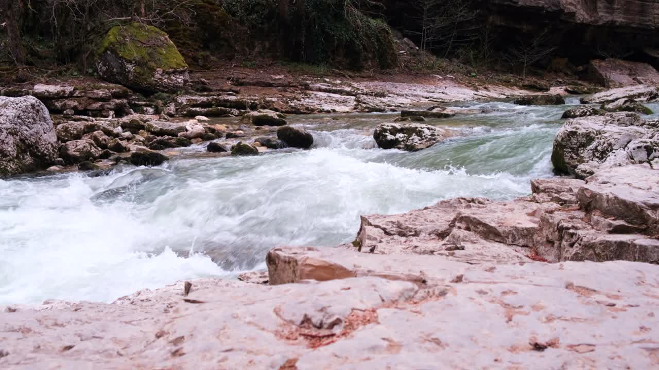 la desembocadura de un río de montaña rocosa fluye. fuerte corriente y agua hirviendo, cascada. el concepto de turismo, senderismo, belleza de la vida silvestre. 4k
