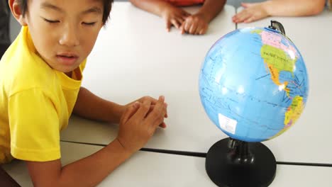 happy school kids with globe in classroom