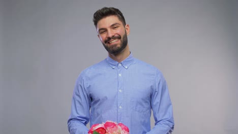 Feliz-Joven-Sonriente-Con-Ramo-De-Flores.-Día-De-San-Valentín,-Saludo-Y-Concepto-De-Vacaciones:-Retrato-En-Video-De-Un-Joven-Feliz-Y-Sonriente-Con-Un-Ramo-De-Flores-Sobre-Fondo-Gris