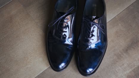 close-up of shiny dress shoes with laces placed on the floor