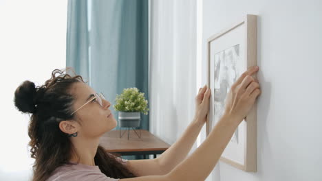 woman hanging a picture