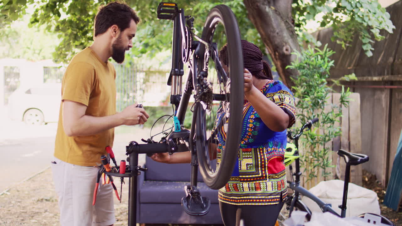 pareja interracial inspeccionando una bicicleta