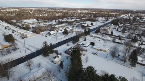 a slowly moving forward snowy winter aerial flyover of a typical michigan residential neighborhood