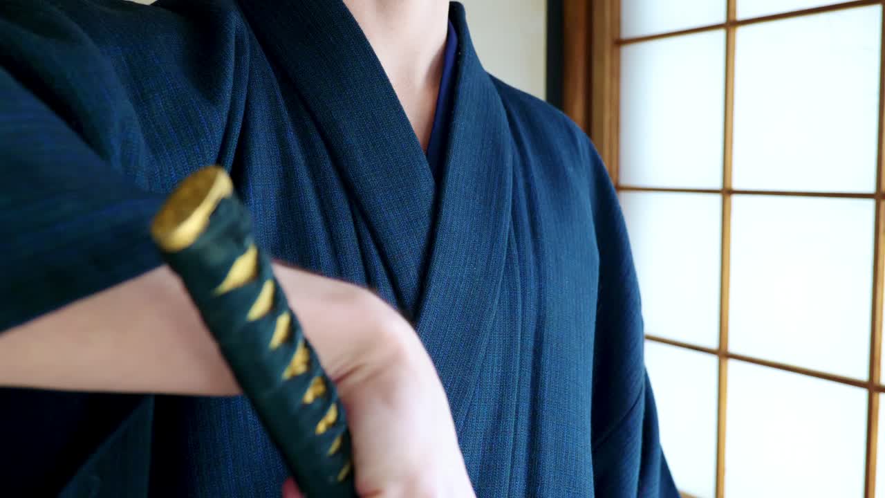 A Man in a Traditional Japanese Kimono with a Samurai's Katana Sword in an Old Traditional Japanese House in Slow Motion