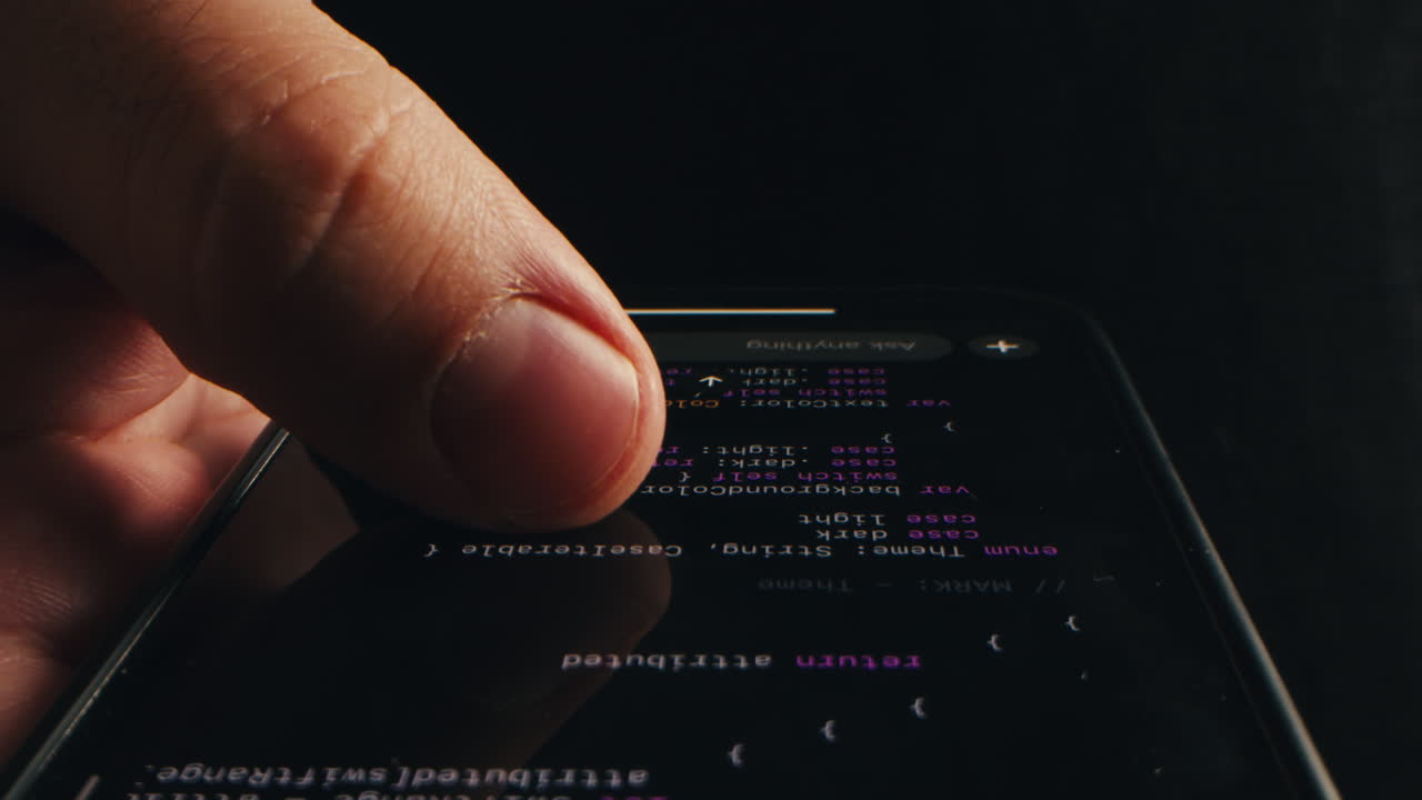 Posouvání prstem po programovacím kódu na obrazovce chytrého telefonu