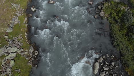 glacial meltwater river fast flowing downstream in summer, norway, aerial view