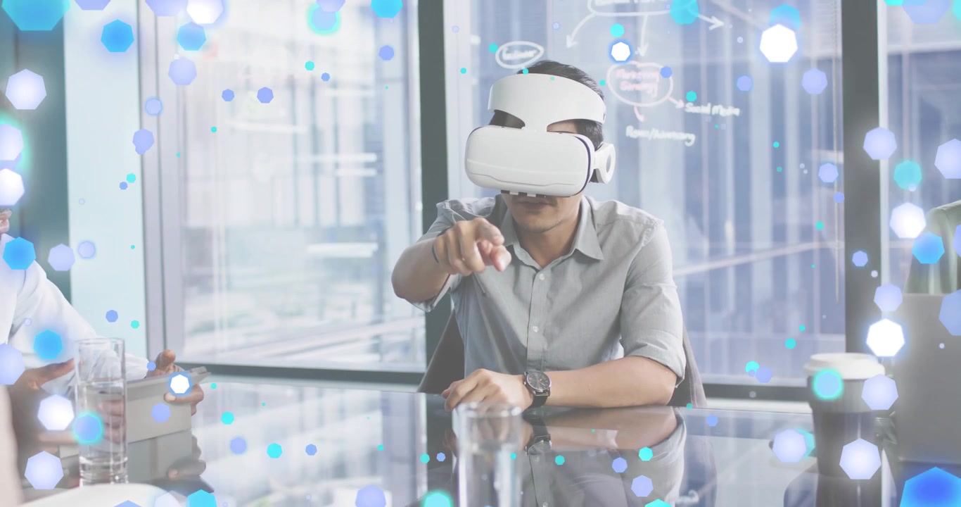 VR 헤드셋을 착용한 성인 남성이 비즈니스 회의에서 입자를 생성하고 가상 데이터를 발표함.