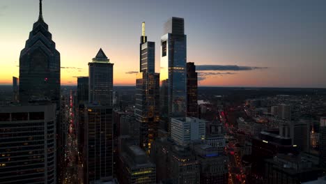 silhouettes of office building towers at sunset