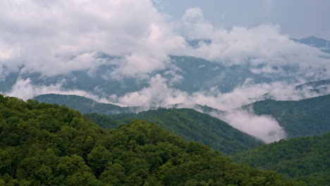 soft tendrils of cloud collide with mountain fog — cinematic drone pass