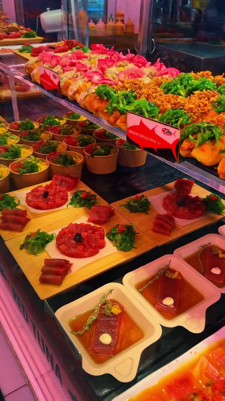Madrid, Spanien, 2. august 2025: Udstilling af frisk tun-tartar og brioche-tapas. Et udvalg af forretter med rå tun, herunder tartar med kaviar og briocheboller, på en madmarkedsudstilling.