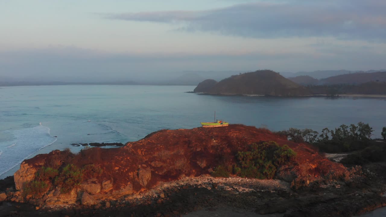 롬복에 있는 게루푹의 서핑 장소에서 일출, 어선과 서퍼가 있는 만의 전망
