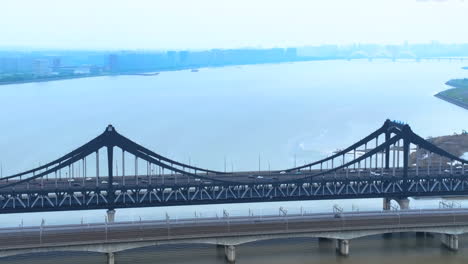 el tiempo de salida del sol en la ciudad de nanjing famoso centro cultural internacional de la juventud puente del río flujo de tráfico hora pico cerca del horizonte rascacielos altos edificios emblemáticos