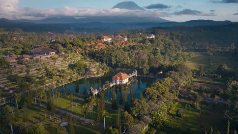 taman ujung royal water palace with active volcano mountain mount agung in the background at sunset, bali, aerial view