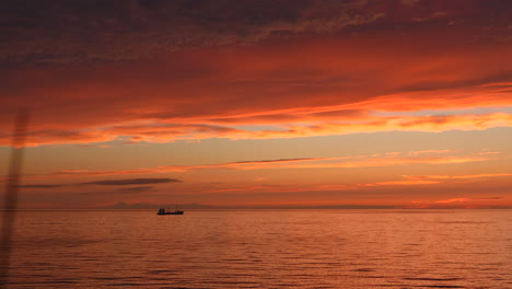 sunset over the ocean with a ship