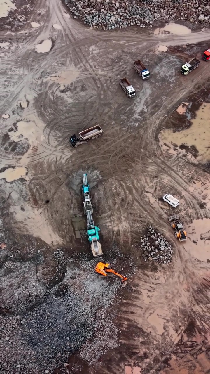 Aerial View of Heavy Machinery Operating in a Muddy Quarry