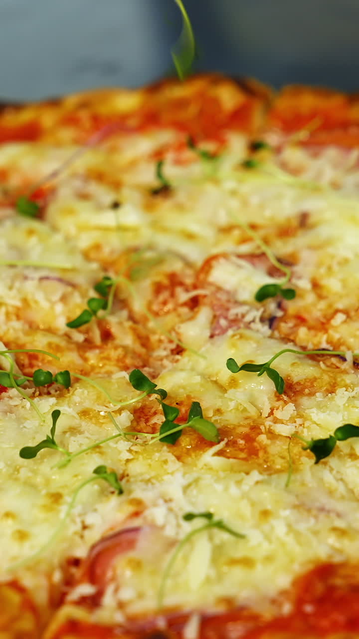 Cook decorates ready pizza. Chef's hand in glove is sprinking fresh green sprouts on a baked pizza in a restaurant. Close-up. Vertical video