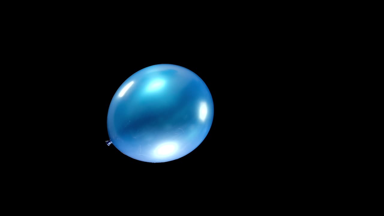 A serene moment as a single blue balloon floats gently in the center of the frame in slow motion. The peaceful, smooth movement captures the beauty of simplicity and calm in the air.