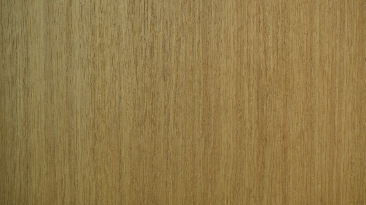 A close-up shot of a pink sticky note on a wooden door, reading 'Went home early'. Note is removed by a hand - close up detail