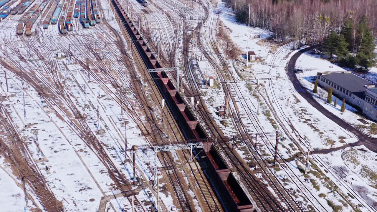 съемка с беспилотника, следующего за длинным пустым товарным поездом через заснеженные зимние пейзажи катовице польша