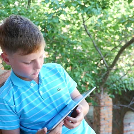 boy using tablet outdoors