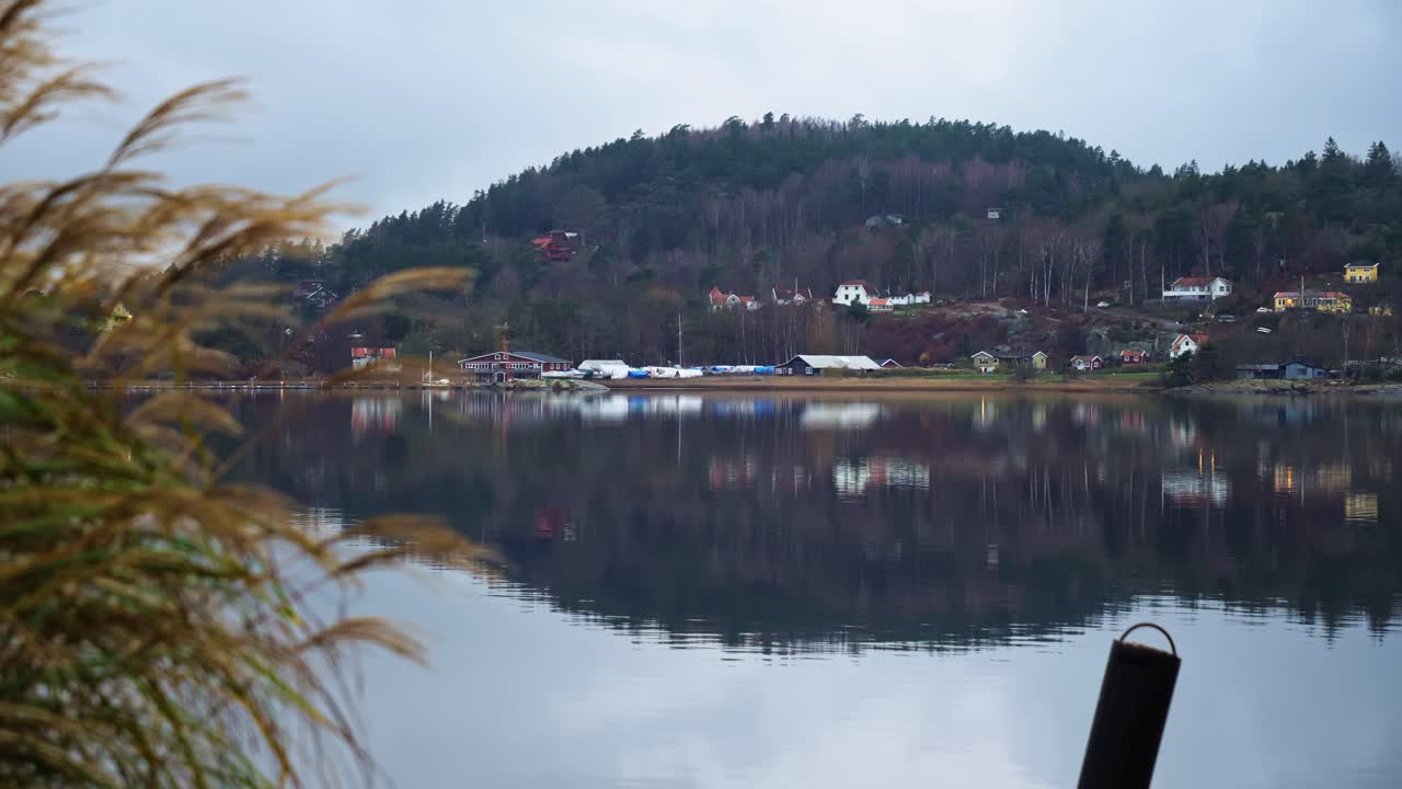 Reflection of peaceful houses and hill on calm water at Havstensfjorden, Ljungskile