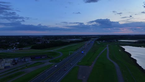 Under-dramatic-and-moody-sunset-sky-vehicles-travel-along-Highway-A15-at-Alblasserdam