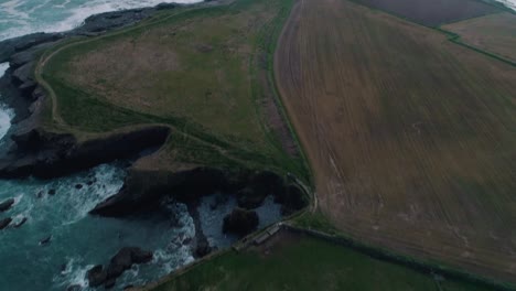 Lighthouse-along-a-rocky-shore-aerial