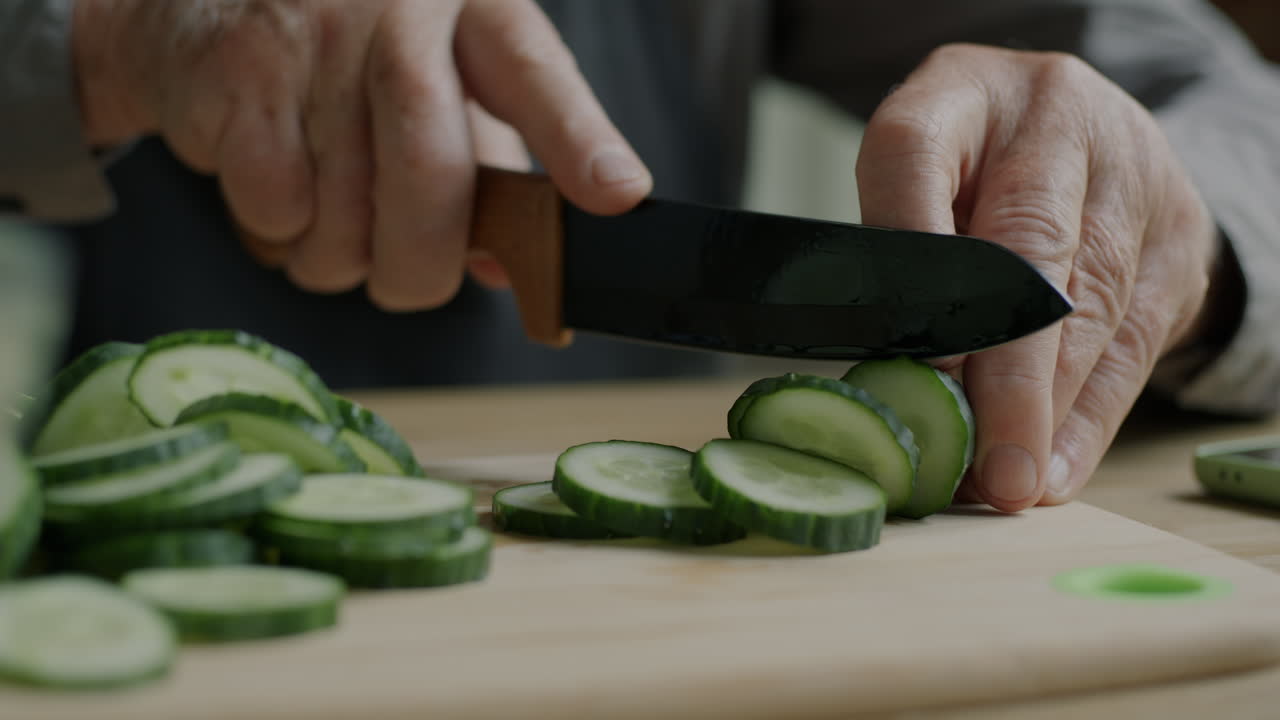 Elderly Person Chopping Cucumbers