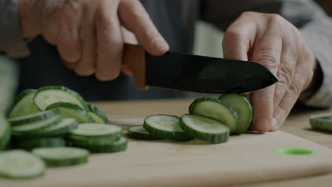 elderly person chopping cucumbers