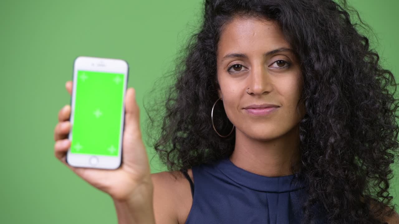 Young beautiful Hispanic businesswoman showing phone