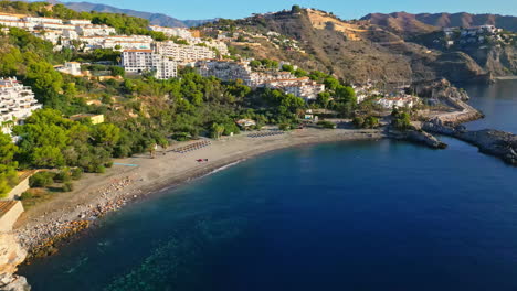 a smooth shot of a suburban village located on a mountain along the coast