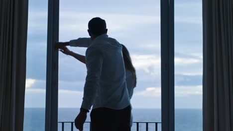 happy young couple dancing in hotel room enjoying successful vacation having fun celebrating on holiday