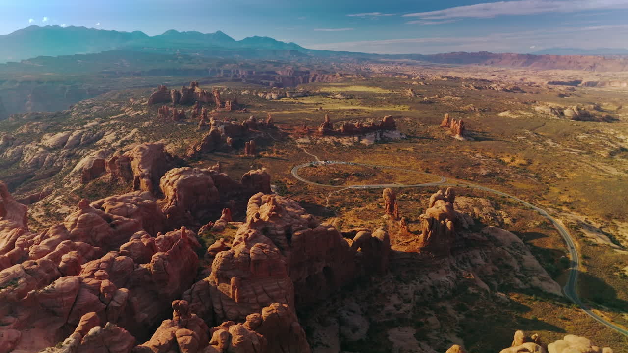 Rounded rocks of Arches National park in Utah, USA. Sunny panorama of mountainous valley at the backdrop of blue sky. Top view.
